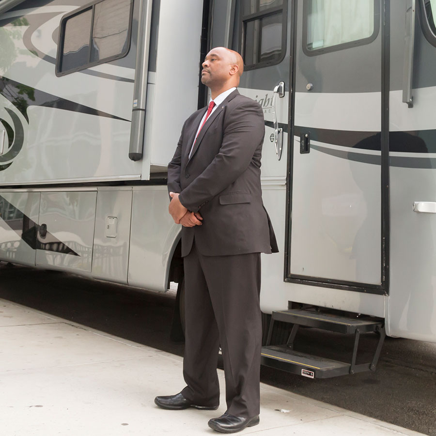 Security guard standing in front of an actors trailer on a movie set