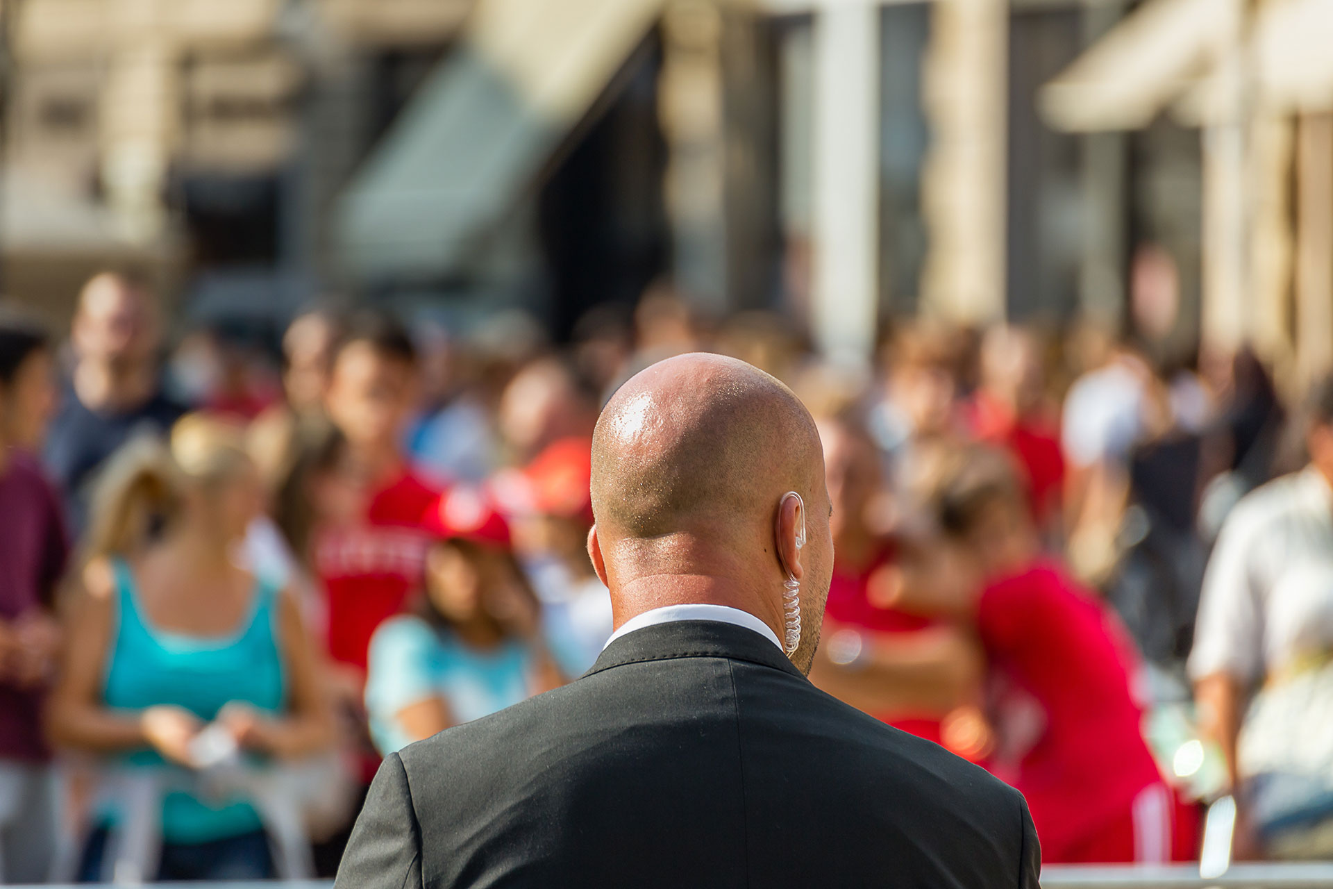 Security Guard in a suit watching a crowd at an event
