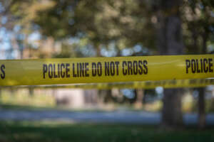 Police tape strung over the outdoor scene of an active shooter scenario