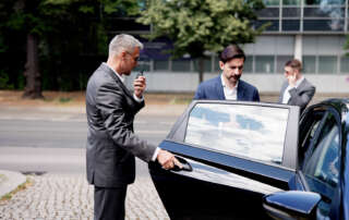 Bodyguard helping his client into a car as part of executive protection