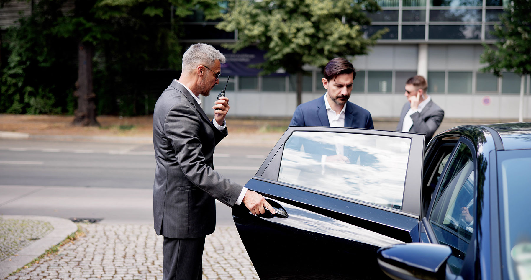 Bodyguard helping his client into a car as part of executive protection