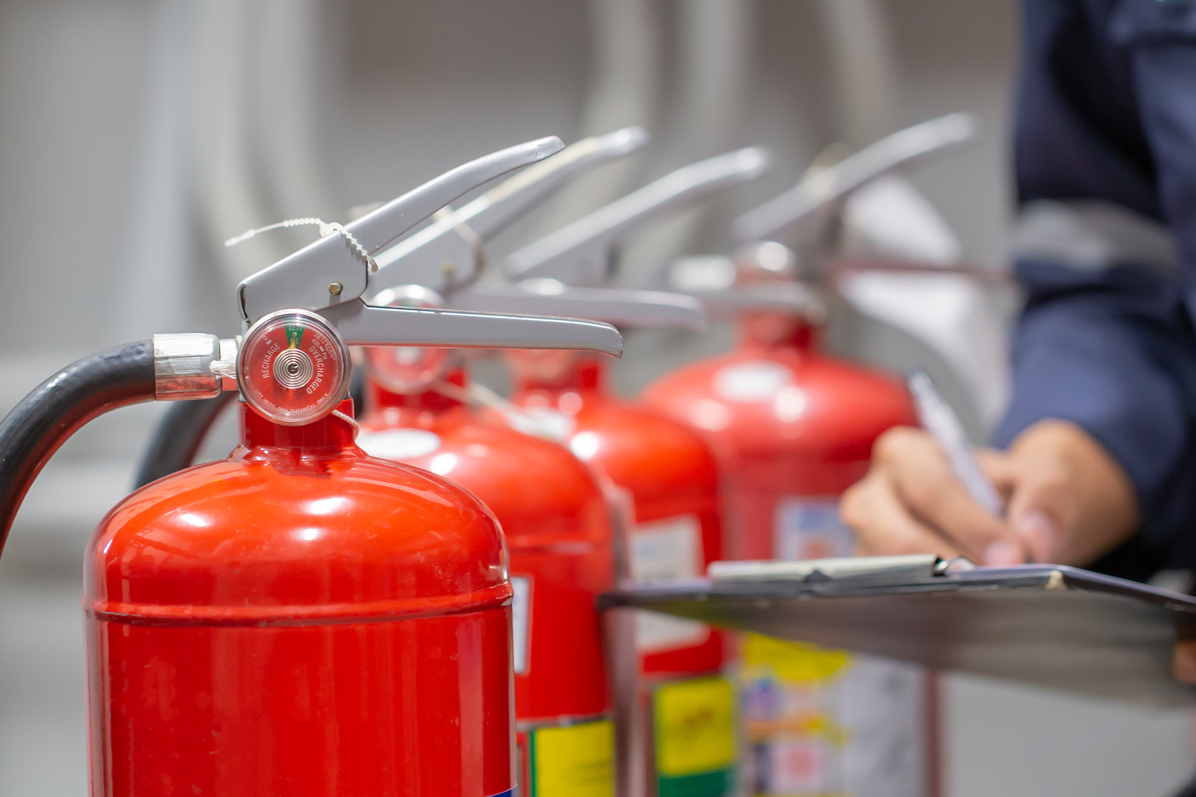 Person inspecting fire extinguishers with a clipboard for FLSD training